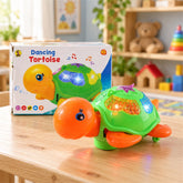 A green and orange plastic tortoise toy with flashing lights sits on a wooden table next to its box.
