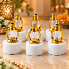 Six unlit miniature lanterns with gold tops and clear glass on white bases are neatly arranged on a polished marble surface.