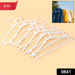 Multiple white plastic clothes hangers on a rack