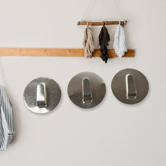 Two self-adhesive hooks mounted on a wall, demonstrating strong adhesion