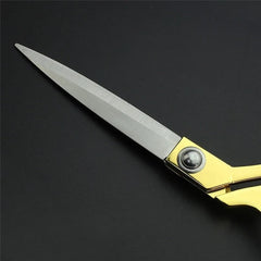 Golden tailoring scissors resting on fabric material