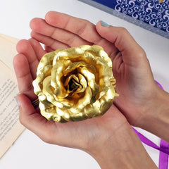 Hand holding a beautiful gold plated artificial rose
