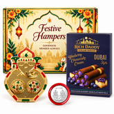 A gold Ganesh kumkum dish, a silver coin, and a box of blueberry cheesecake wafer rolls on a white surface.
