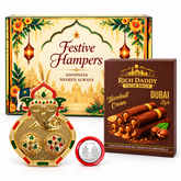 A gold Ganesh kumkum dish with red and green accents, a box of hazelnut wafer rolls, and a silver coin in a red holder, all