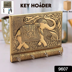 Close-up of gold elephant trunk key hook on wooden base