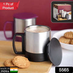 Person holding a stainless steel travel mug