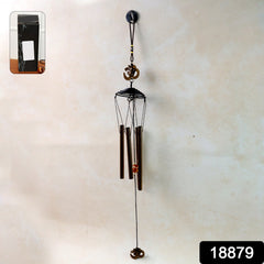 Close-up of metal wind chime with Om symbol and tuned tubes