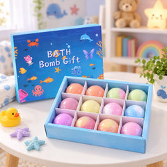 Twelve colorful bath bombs in a blue gift box with sea creature illustrations, next to a rubber duck and starfish toys.