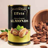 Black and gold cylindrical tin of Effete Choco Coated Almonds, with loose almonds and a wooden bowl beside it.