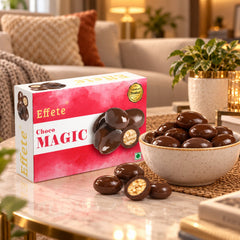 A box of Effete Choco Magic and a bowl of the round, dark brown chocolates with one cut open to show the light crispy