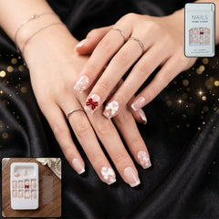 A woman's hand showcasing beautiful glitter 3D floral press-on nail tips with a detailed thumb design.