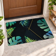 A rectangular black mat with vibrant green and blue tropical leaf designs lies on a light tiled floor.