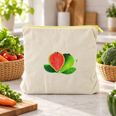 Cream cotton storage bag with a guava print, empty on a kitchen counter with vegetables in baskets.