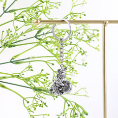 Angled view of silver Bal Krishna metal keychain
