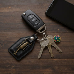Side view of metal sword emblem on leather keychain