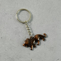 Antique finish lion metal keychain on a plain surface