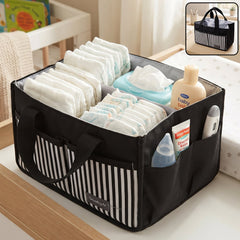 A black and white striped travel organizer bag caddy holds diapers, wipes, lotion, and a thermometer on a changing table.
