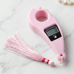 Close-up of pink digital mantra jaap counter with button and LCD screen pooja accessories