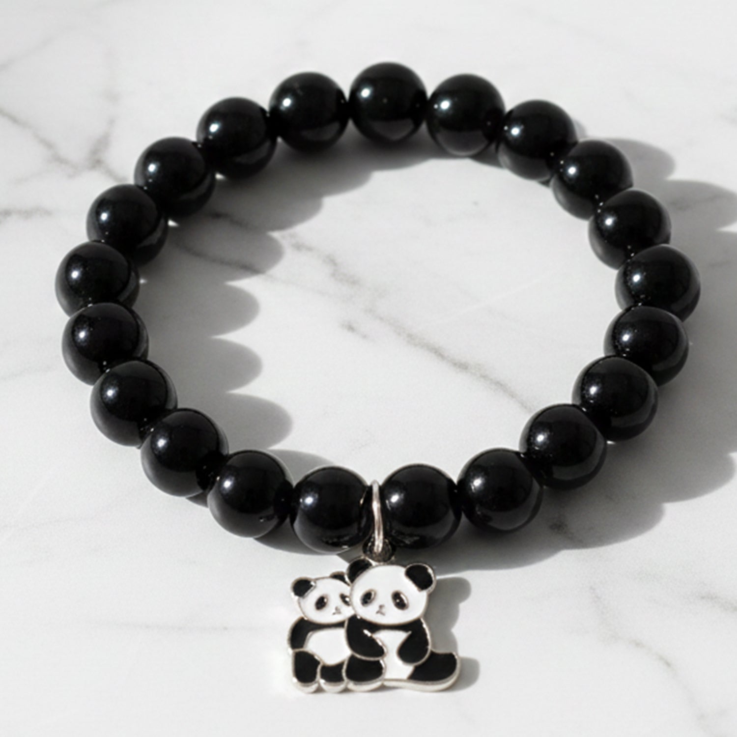 Black beaded stretch bracelet with panda charm on a white background