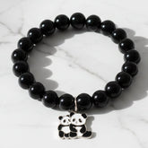 Black beaded stretch bracelet with panda charm on a white background