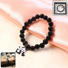 Close-up of black beaded bracelet with detailed panda charm