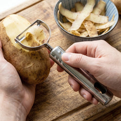 Peeler with sliced potatoes and carrots