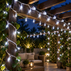 White LED string lights wrapped around a wooden pergola in an outdoor seating area at dusk.