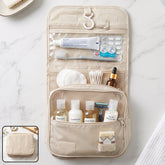 A beige hanging toiletry bag filled with travel-sized toiletries, including shampoo, conditioner, and body wash bottles.