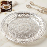 Elegant silver round serving tray with embossed floral design and lattice border