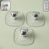 Clear plastic adhesive wall hooks mounted on white wall holding keys and bags