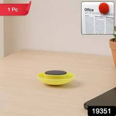 Hand placing a yellow circular magnet to hold paper
