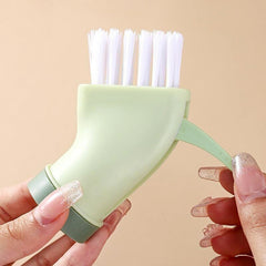 Dual-action scrubbing brush with nozzle and scraper for narrow grooves