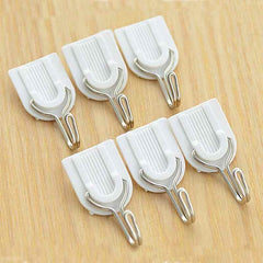 Self-adhesive plastic hook holding towels on a smooth wall.