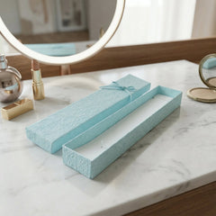 Long rectangular jewelry box with decorative ribbon closure