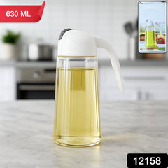 Close-up of glass oil bottle dispenser tilted to pour oil