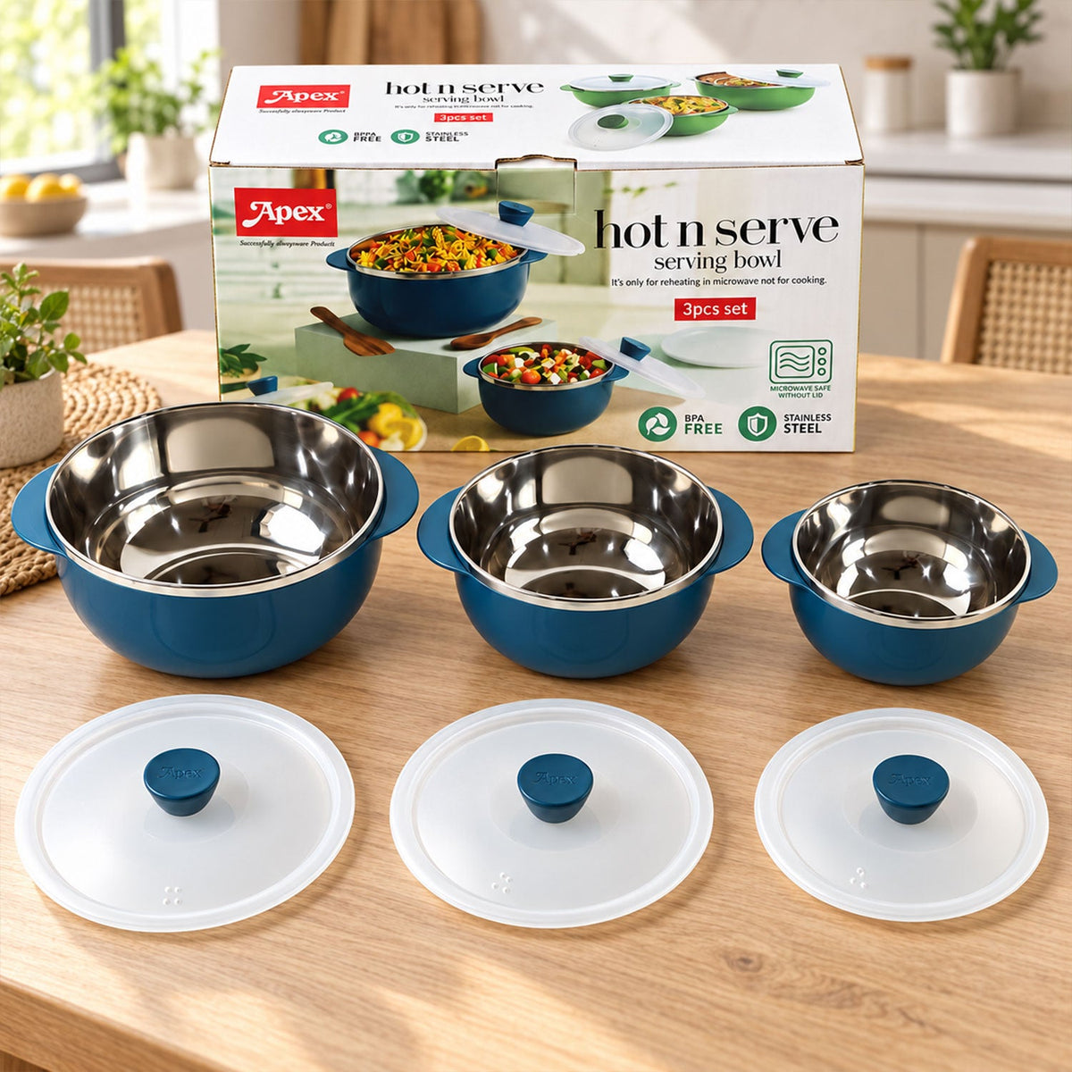 Three blue serving bowls with stainless steel interiors and clear lids are displayed on a wooden table with their packaging