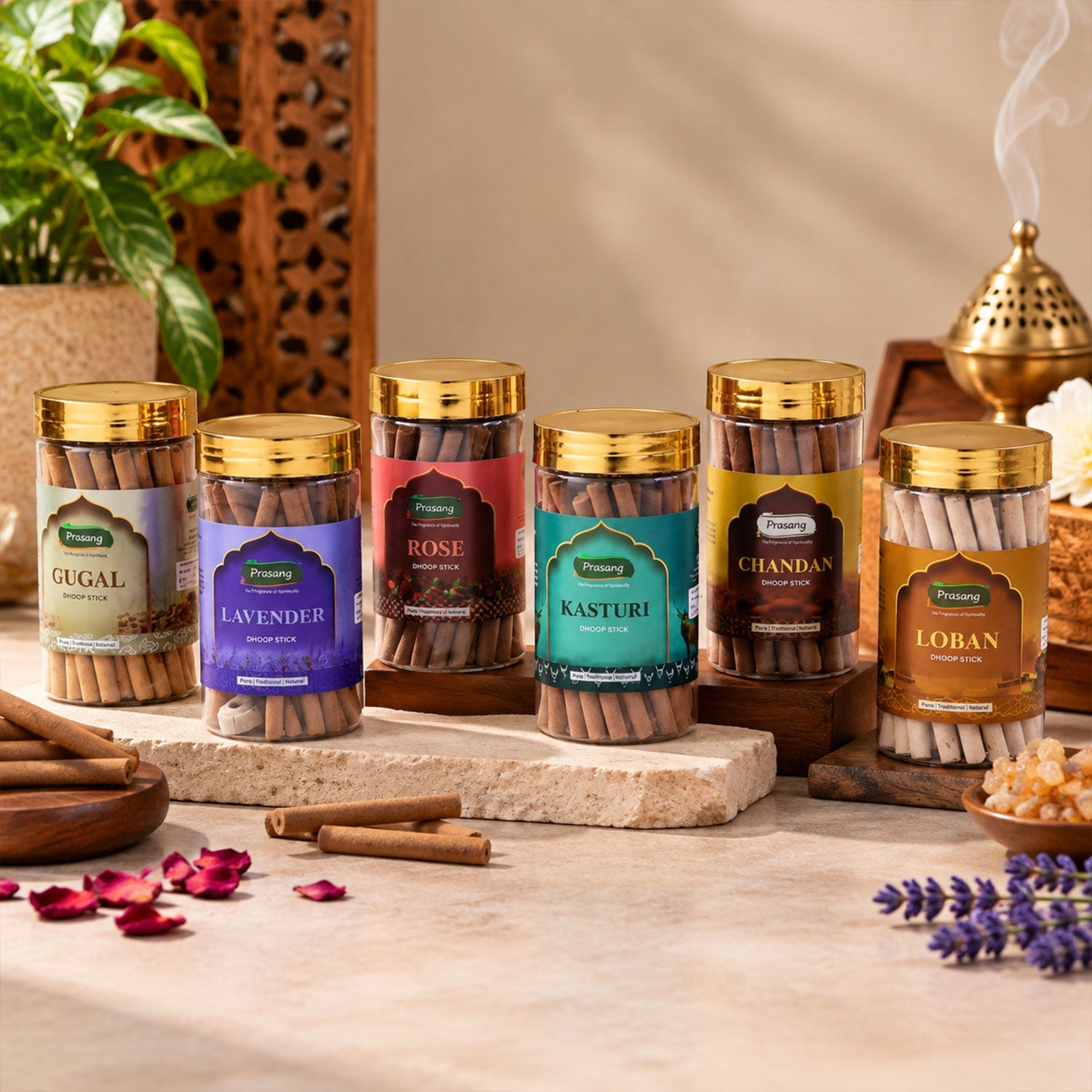 Six clear jars of dhoop sticks with gold lids, arranged on a stone surface with a lit stick and flower petals.