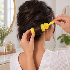 A woman with dark hair uses a single yellow foam roller to create a curl.