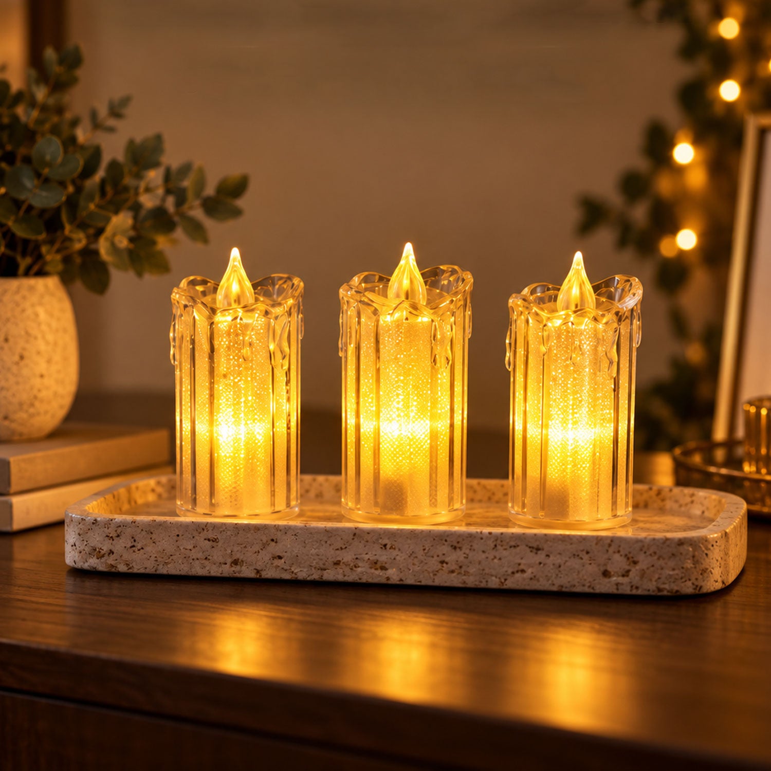 Three illuminated clear plastic LED candles with a flickering flame effect, casting a soft yellow light on a wooden surface.