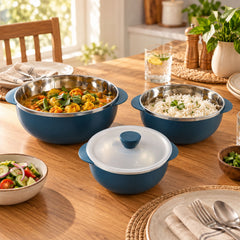 A dining table scene features three blue serving bowls, two filled with food, alongside other dinnerware and drinks.
