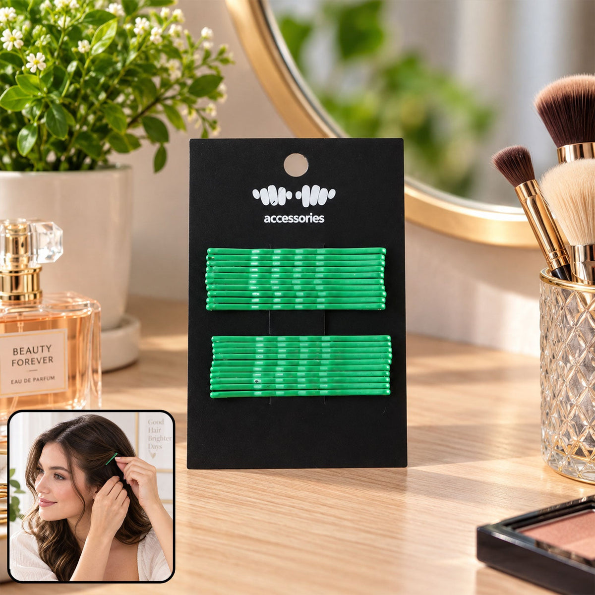 A black card holds two rows of green metal bobby pins on a wooden vanity beside perfume and makeup brushes. A small inset