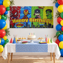 Happy Birthday superhero backdrop behind a blue checkered cake table and balloons