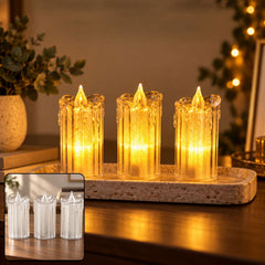 Three clear plastic LED candles with warm yellow glow on a textured rectangular tray, surrounded by dim ambient light and a