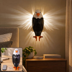 A geometric black and white eagle wall light illuminates a bedroom wall above a wooden nightstand with a plant.