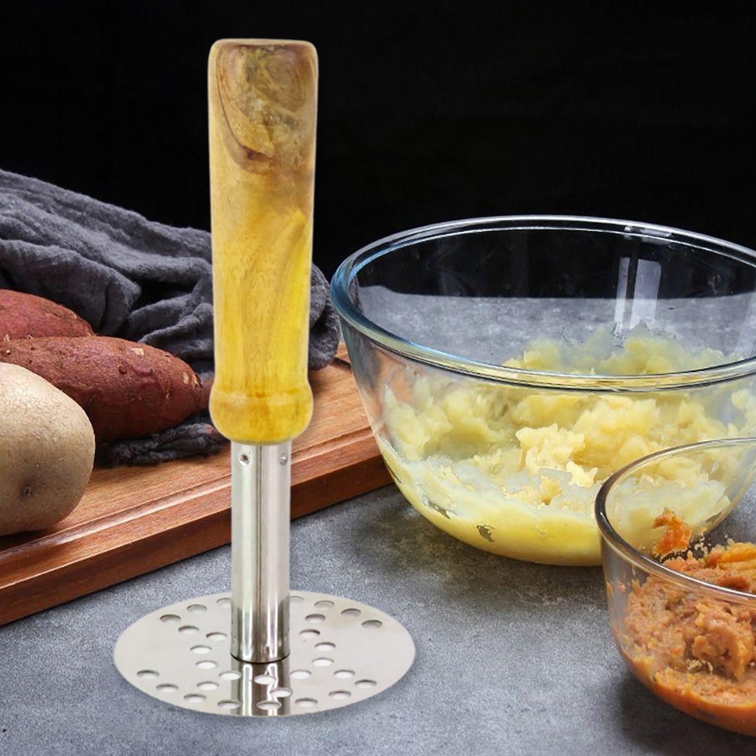 Potato masher placed next to bowl of mashed potatoes