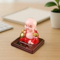 Solar powered Buddha statue on car dashboard