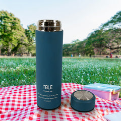 An individual enjoying a drink from the 500ml unbreakable water bottle during an outdoor hike.
