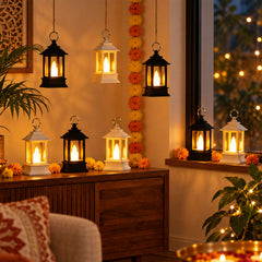 Eight small black and white lanterns with glowing LED candles are placed on a wooden console and window sill, surrounded by