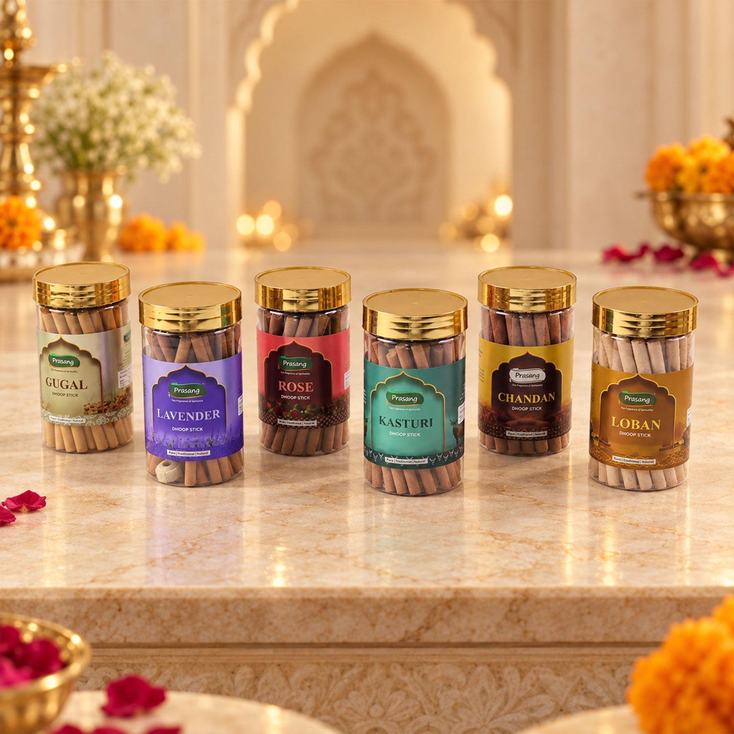 Six clear jars of dhoop sticks with gold lids, arranged on a marble surface in a decorative setting.