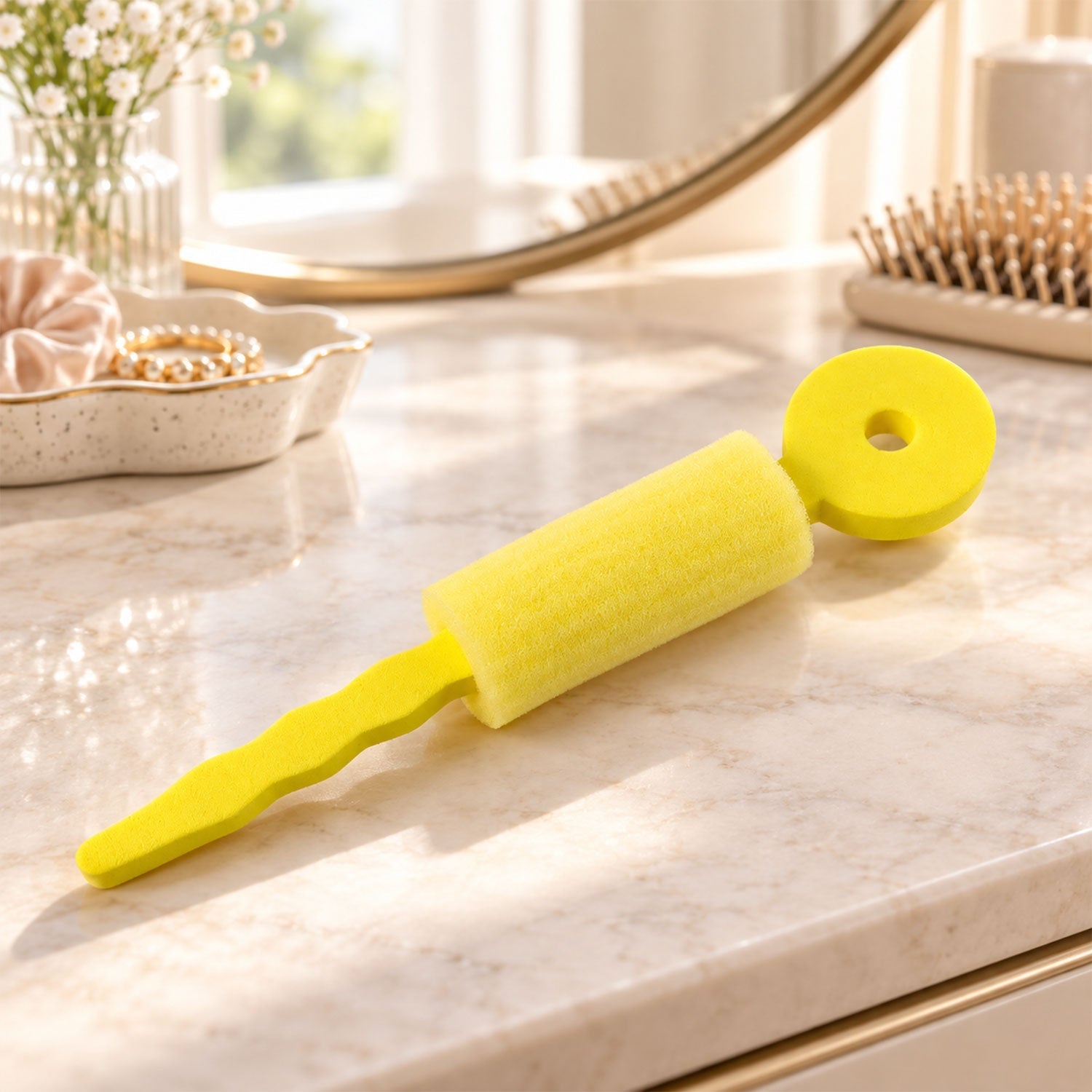 A yellow foam hair roller rests on a marble vanity counter with a mirror and brush.